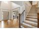 Bright foyer with hardwood floors, staircase, view to dining area and exterior door at 2660 Burnt Hickory Dr, Cumming, GA 30028