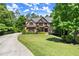 Stunning brick home with lush landscaping, sprawling green lawn, and long private driveway at 2660 Burnt Hickory Dr, Cumming, GA 30028