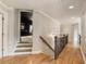 Upstairs hallway with hardwood floors and railing overlooking a bedroom at 2660 Burnt Hickory Dr, Cumming, GA 30028