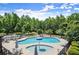 Community pool featuring ample seating, an umbrella, a splash pad, and lush greenery at 2660 Burnt Hickory Dr, Cumming, GA 30028