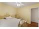 Bedroom featuring bright yellow walls, wood floors, a ceiling fan, and a decorative metal bed frame at 6637 Oak Farm Se Dr, Acworth, GA 30102