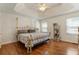Bright bedroom features a tray ceiling, ceiling fan, hardwood floors, and a decorative metal bed frame at 6637 Oak Farm Se Dr, Acworth, GA 30102