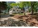 A white home featuring a two-car garage and well-kept lawn situated on a lush lot with mature trees at 6637 Oak Farm Se Dr, Acworth, GA 30102