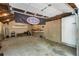 View of a garage interior with exposed ceiling, a banner, shelving, and walls painted in neutral tones at 6637 Oak Farm Se Dr, Acworth, GA 30102