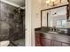 Bathroom featuring a tiled shower with a dark wood vanity and granite countertop at 2161 Peachtree Rd # Apt 706, Atlanta, GA 30309