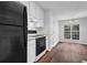 Bright kitchen with white cabinetry, an oven, and a black refrigerator at 3020 Meadow Glen Pass, Fairburn, GA 30213