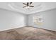 Spacious main bedroom featuring a tray ceiling and ceiling fan at 3020 Meadow Glen Pass, Fairburn, GA 30213