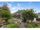 Beautifully landscaped backyard with lush greenery, stone pathway, and a peek at the screened-in porch at 3302 Anna Ruby Ln, Buford, GA 30519