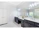 Bathroom with double sinks, modern vanities, large mirror, and walk-in shower with marble details at 3302 Anna Ruby Ln, Buford, GA 30519