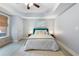 Cozy bedroom featuring a tray ceiling, neutral decor, and natural lighting at 3302 Anna Ruby Ln, Buford, GA 30519