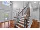 Grand foyer with hardwood floors, staircase, and iron railings, creating a sophisticated entrance at 3302 Anna Ruby Ln, Buford, GA 30519