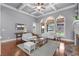 Bright living room featuring coffered ceilings, arched windows, and a stone fireplace at 3302 Anna Ruby Ln, Buford, GA 30519