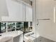 A modern bathroom with a glass-enclosed shower, soaking tub, and bright window overlooking city buildings at 40 12Th Ne St # 1406, Atlanta, GA 30309