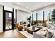Bright living room with hardwood floors, modern furniture, fireplace, and floor to ceiling windows with city views at 40 12Th Ne St # 1406, Atlanta, GA 30309