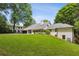 Expansive backyard with well-manicured lawn and mature trees, complete with a white brick home at 4708 Tall Pines Nw Dr, Atlanta, GA 30327