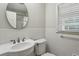 This bathroom features a porcelain pedestal sink, commode, and bright window at 4708 Tall Pines Nw Dr, Atlanta, GA 30327