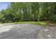 Long driveway extends to the garage and landscaped yard surrounded by mature trees at 4708 Tall Pines Nw Dr, Atlanta, GA 30327