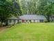 Charming single-story home with a lush green lawn and a welcoming red front door at 4708 Tall Pines Nw Dr, Atlanta, GA 30327