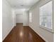 Hallway featuring white trim and baseboards, hardwood floors and natural light from the two windows at 4708 Tall Pines Nw Dr, Atlanta, GA 30327