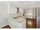Eat-in kitchen with stainless steel appliances, white cabinets, granite countertops, and hardwood floors at 4708 Tall Pines Nw Dr, Atlanta, GA 30327