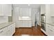 Bright white kitchen featuring stainless steel double oven, stone countertops, and hardwood floors at 4708 Tall Pines Nw Dr, Atlanta, GA 30327