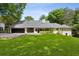 View of the back of a large home with lush green lawn and attached garage at 4708 Tall Pines Nw Dr, Atlanta, GA 30327