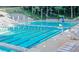 Large swimming pool with lap lanes, lounge chairs, tables, and umbrellas, perfect for relaxation and recreation at 4708 Tall Pines Nw Dr, Atlanta, GA 30327