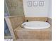 An elegant bathroom featuring a corner shower and soaking tub surrounded by stylish neutral colored tile at 359 Alderwood Ln, Atlanta, GA 30328