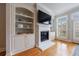 Bright living room featuring a fireplace, custom built-ins, and gleaming hardwood floors at 359 Alderwood Ln, Atlanta, GA 30328