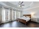 Tranquil main bedroom with tray ceiling, large windows, and warm wood-look flooring at 359 Alderwood Ln, Atlanta, GA 30328
