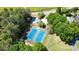 Aerial view showcasing tennis courts and a sparkling pool surrounded by lush greenery for resort-style living at 3740 Duckcove Way, Cumming, GA 30041