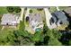 Aerial view showcasing home with backyard pool, landscaped yard, and wooded surroundings at 3740 Duckcove Way, Cumming, GA 30041