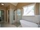 Bright bathroom featuring a standing shower and a soaking tub beneath a window with sheer curtains at 3740 Duckcove Way, Cumming, GA 30041