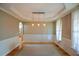 Dining room with paneled walls, an elegant tray ceiling, hardwood floors, and an arched entrance to another room at 3740 Duckcove Way, Cumming, GA 30041
