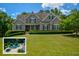 Charming traditional home boasts a lush front lawn and mature landscaping, creating a welcoming curb appeal at 3740 Duckcove Way, Cumming, GA 30041