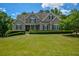 Charming home featuring manicured lawn, beautiful landscaping, and classic architectural details for a stunning curb appeal at 3740 Duckcove Way, Cumming, GA 30041