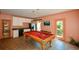 Billiards table with an adjacent kitchenette with black appliances at 3740 Duckcove Way, Cumming, GA 30041