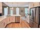 Open-concept kitchen with stainless steel fridge, quartz countertops and sun-lit breakfast nook at 3740 Duckcove Way, Cumming, GA 30041