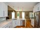 Open kitchen featuring marble countertops, stainless appliances, and a view of the dining area at 3740 Duckcove Way, Cumming, GA 30041