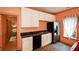 Efficient kitchenette featuring white cabinets, black appliances, and a window at 3740 Duckcove Way, Cumming, GA 30041