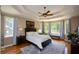Cozy main bedroom with tray ceilings, large windows, and hardwood floors at 3740 Duckcove Way, Cumming, GA 30041