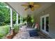 Covered patio with a ceiling fan and stone flooring, overlooking lush landscaping at 3740 Duckcove Way, Cumming, GA 30041
