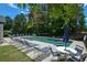 Outdoor pool area with lounge chairs, tables, umbrellas, and a sparkling pool for relaxation at 3740 Duckcove Way, Cumming, GA 30041