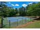 Outdoor tennis courts surrounded by lush trees and greenery, providing a private and scenic playing experience at 3740 Duckcove Way, Cumming, GA 30041