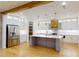 Open-concept kitchen boasts an island, stainless steel appliances, white cabinets, and hardwood flooring at 3774 Eli Dr, Snellville, GA 30039