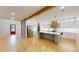 Spacious kitchen with stainless appliances, island, flows into the foyer with hardwood floors and brick accent wall at 3774 Eli Dr, Snellville, GA 30039
