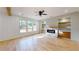 Inviting living room with a fireplace, built-in shelving, large windows, ceiling fan, and gleaming hardwood floors at 3774 Eli Dr, Snellville, GA 30039