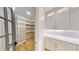 Well-organized walk-in pantry featuring custom shelving and cabinets adjacent to white cabinets with gold hardware at 3774 Eli Dr, Snellville, GA 30039