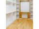 A stunning walk-in closet with built in shelving, wooden floors, and a dresser at 3774 Eli Dr, Snellville, GA 30039