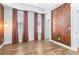 Bedroom featuring light wood floors, three large windows and two wood accent walls at 4462 Dandelion Ln, Atlanta, GA 30342